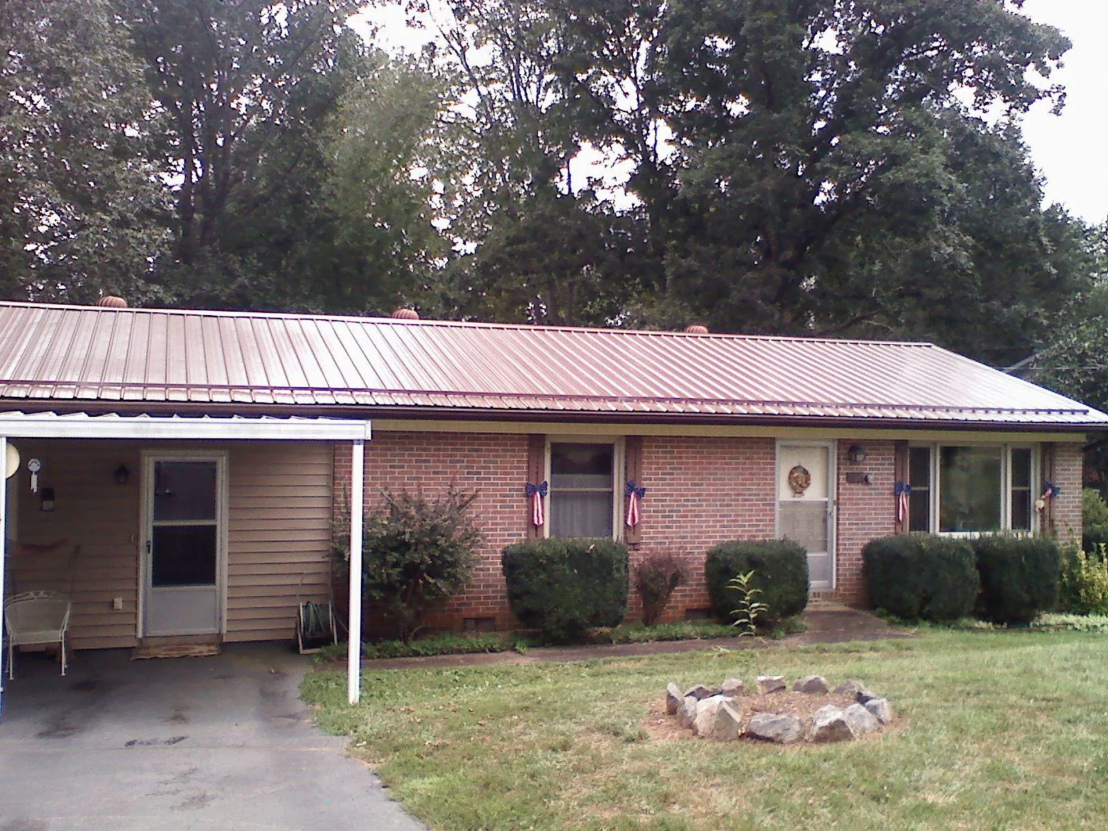 Bronze metal roof and carport on a brick ranch home — Roof Repair work by our crew in Wheatland